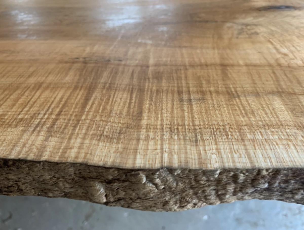 Close-up of a live edge slab surface with natural bark edge